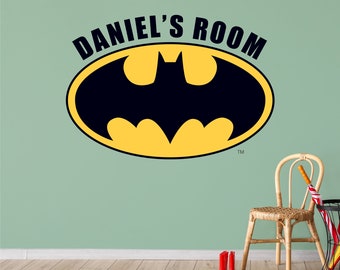 May include: A yellow and black Batman logo with the text "DANIEL'S ROOM" above it. The logo is on a light green wall.