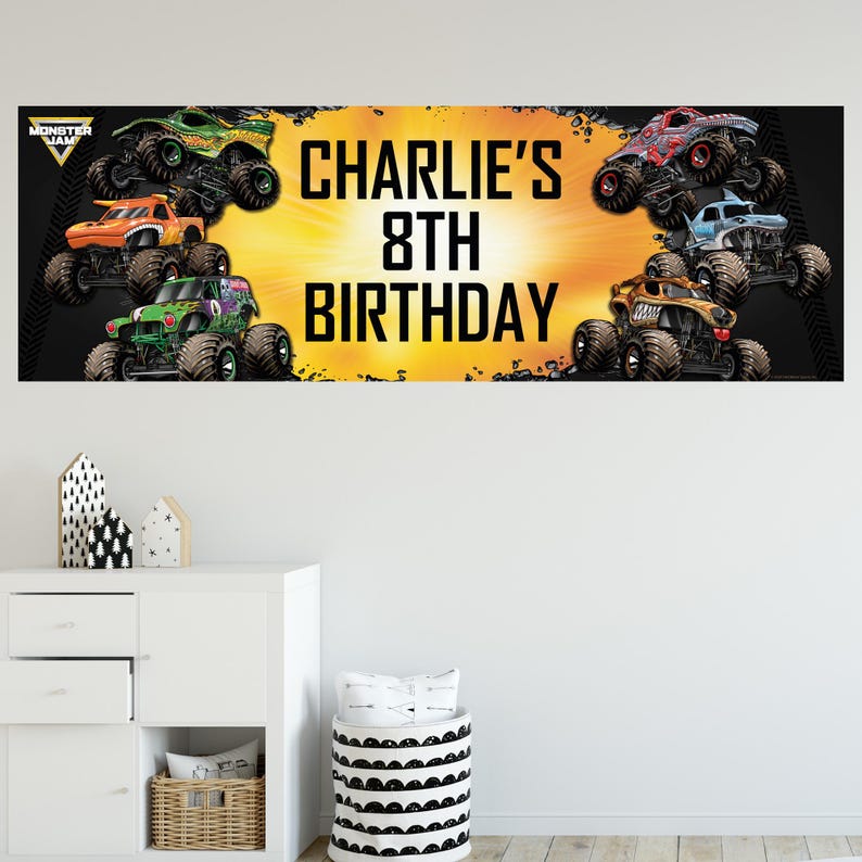 May include: A banner featuring several monster trucks in various colors, including green, orange, and red, against a yellow and black background. The text "CHARLIE'S 8TH BIRTHDAY" is prominently displayed.