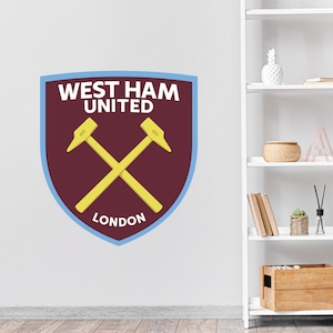 May include: West Ham United Football Club crest with crossed hammers, a maroon shield, and the words "West Ham United" and "London" in white.