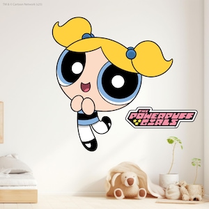 Puede incluir: Un vinilo decorativo de pared con Bubbles de la serie animada The Powerpuff Girls. Bubbles tiene coletas rubias, ojos azules y un atuendo negro y azul. El logotipo de The Powerpuff Girls también está presente.