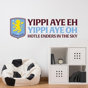 May include: A white wall with a burgundy and blue wall decal that says "Yippi Aye Eh Yippi Aye Oh Hotle Enders In The Sky". The decal also features a crest with a lion and the words "Aston Villa 1874".