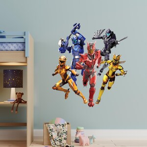 May include: Wall decal featuring six action figures in dynamic poses. The figures are clad in vibrant armor, with colors including red, blue, yellow, and black. The figures appear to be in motion, suggesting a theme of action and adventure.