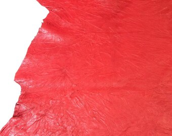 May include: A large piece of red leather with a textured surface. The leather is measured with a ruler, showing it is approximately 40 inches long.