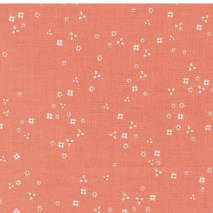 May include: Coral-colored fabric with a delicate floral pattern. Small white flowers with three petals are scattered across the surface. The fabric has a subtle texture, creating a soft and inviting aesthetic. Ideal for crafting or sewing projects.