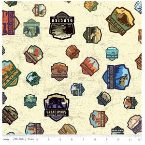 May include: A beige fabric with a repeating pattern of colorful national park patches. The patches feature various park names, such as "Grand Canyon", "Yosemite", "Zion", and "Great Smoky Mountains".