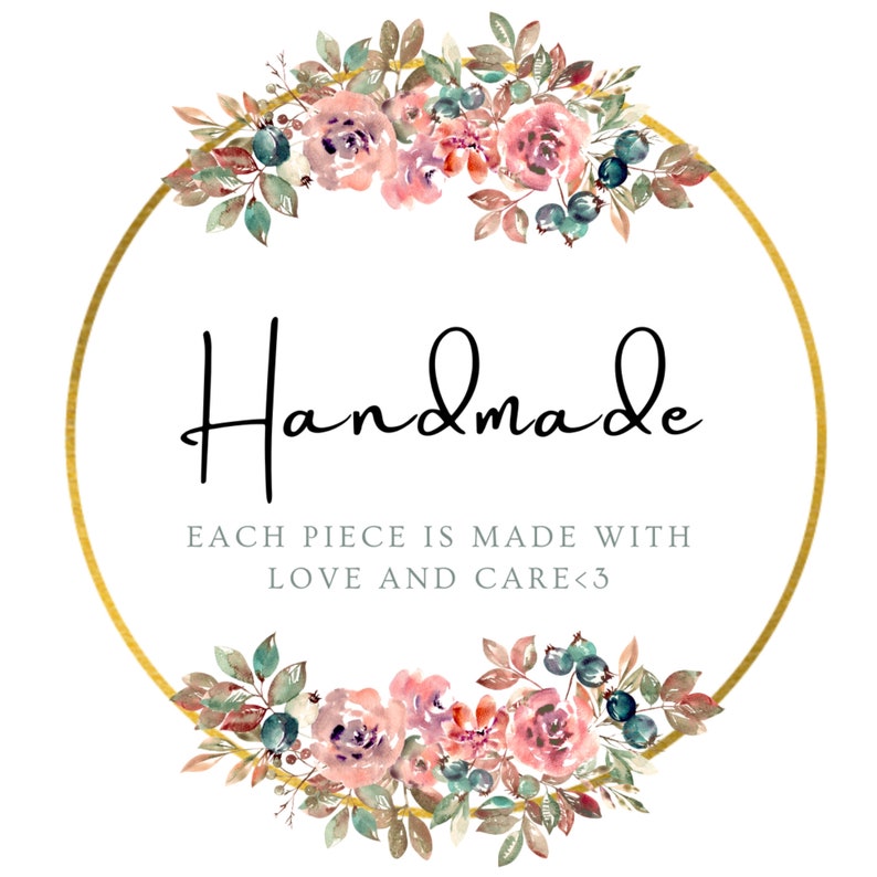 May include: A gold circle with a floral wreath around it. The wreath is made of pink and purple flowers, green leaves, and blue berries. The text "Handmade" is written in black cursive inside the circle. Below the text is the phrase "Each piece is made with love and care<3".