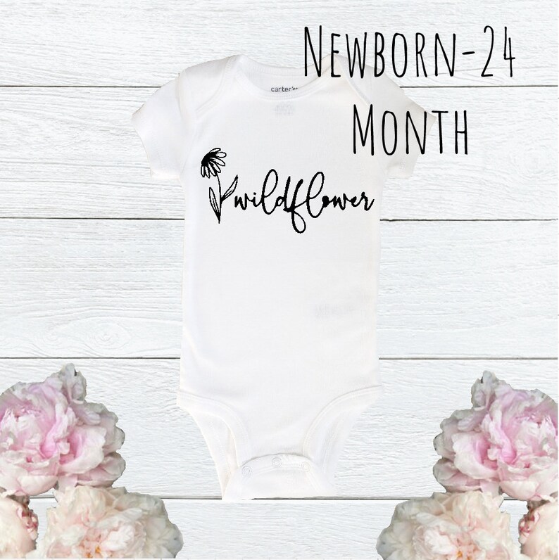 May include: White baby onesie with black text that reads "NEWBORN-24 MONTH Wildflower" and a small black flower graphic.