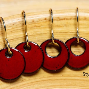 May include: Four pairs of red enamel earrings with silver hooks. Two pairs have a circle cutout in the center, labeled "Style B". The other two pairs are solid red circles, labeled "Style A".