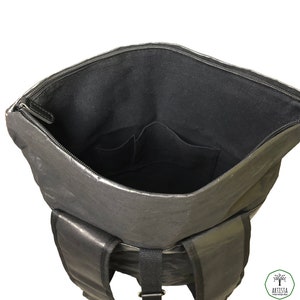 May include: Black backpack with a zippered top and two adjustable straps. The inside of the backpack is lined with black fabric and has two small pockets.
