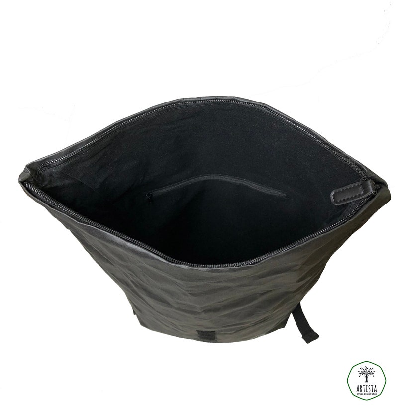 May include: Black backpack with a zippered top opening. The inside of the backpack is lined with black fabric and has a small zippered pocket.
