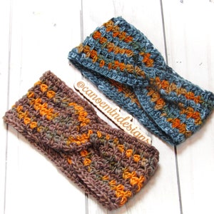 May include: Two crocheted headbands in a brown and orange color combination and a blue and orange color combination. The headbands are on a white wooden surface. The text "@canoeintridesigns" is written on a wooden tag.
