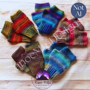 May include: Five pairs of fingerless gloves arranged in a circle, each featuring a distinct multi-coloured gradient yarn pattern. The colours include red, orange, yellow, green, blue, purple, and brown tones. A circular logo with the text Canoe Mtn DESIGNS is visible at the bottom, and a blue circle with the text Not AI is in the top right corner.