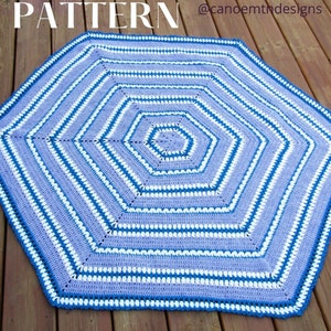 Op de afbeelding: Een gehaakt octagon tapijt met een gestreept patroon in blauw, wit en paars. Het tapijt is gemaakt met een enkele haaksteek en heeft een textuur. @canoemthdesigns