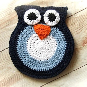 May include: A crocheted owl toy with blue, white, and orange yarn. The owl has large black eyes and a round body.