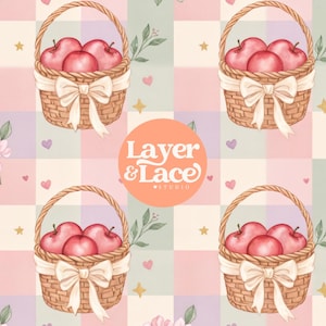 Op de afbeelding: Een herhalend patroon met gevlochten bruine manden gevuld met rode appels, elk versierd met een crèmekleurige strik. De achtergrond bestaat uit een pastelkleurig ruitjespatroon in roze, groen en paars, geaccentueerd met kleine gouden sterretjes en hartjes. Een rond oranje logo bevat de tekst Layer & Lace Studio.