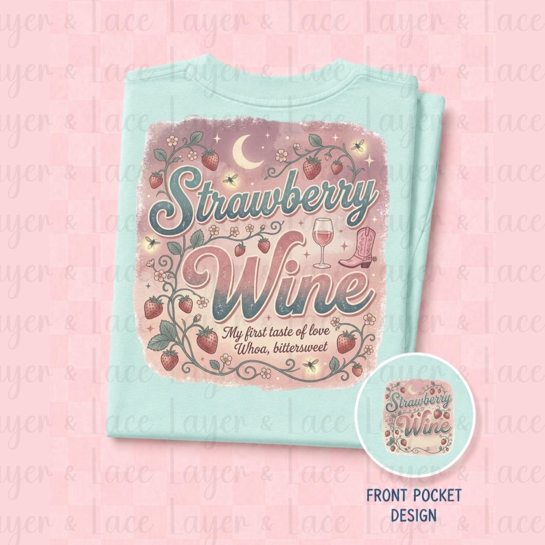 May include: A light mint green t-shirt featuring a graphic print with the text Strawberry Wine My first taste of love Whoa, bittersweet. The design includes illustrations of strawberries, vines, a wine glass, a crescent moon, and a cowboy boot.