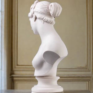 May include: White plaster bust sculpture of a woman with her hair pulled back in a bun. The bust is on a white pedestal.