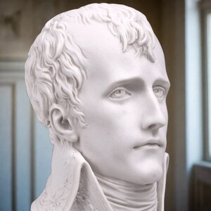 May include: A white marble bust sculpture of a man with short hair. The sculpture is detailed and realistic, capturing the man's facial features.