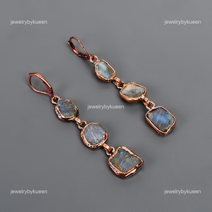 May include: A pair of copper earrings with four iridescent labradorite stones hanging from each earring. The stones are different shapes and sizes, and the copper wire is wrapped around the edges of the stones.