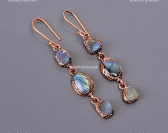 May include: A pair of long, copper dangle earrings featuring multiple iridescent blue labradorite stones. The stones are set in copper wire and have a natural, irregular shape.
