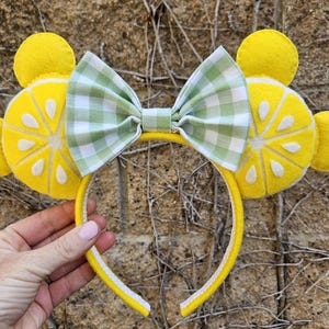 May include: Yellow felt lemon slice headband with a green and white gingham bow.