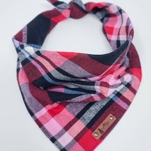 May include: Red, black, pink, and blue plaid dog bandana with a brown leather patch that says "Made with Love".