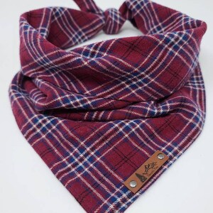 May include: Red and blue plaid bandana with a brown leather patch that says "Pacific Rim" with a mountain and pine tree design.