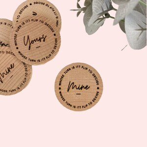 May include: Wooden game pieces with the text "Whose turn is it? Flip to decide" and the words "Yours" and "Mine" written on them.