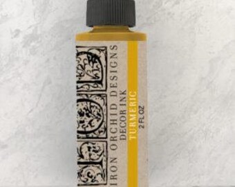 May include: A 2 fl oz bottle of Iron Orchid Designs Decor Ink in the color Turmeric. The bottle is yellow with a black dropper top and a white label with the brand name and color name.