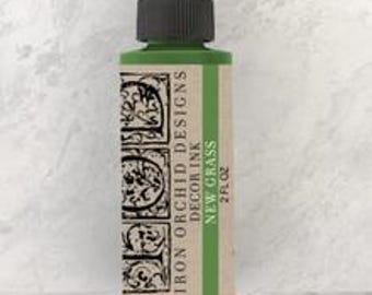May include: A 2 fl oz bottle of Iron Orchid Designs DecoArt Ink in the color New Grass. The bottle is green with a black dropper top and a white label with black text.