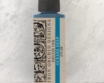 May include: A 2 fl oz bottle of Iron Orchid Designs Decor Ink in the color Oceans Deep, a deep blue color. The bottle has a black cap with a dropper.