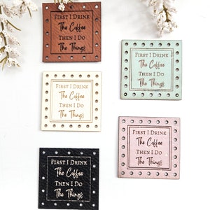 May include: Five square leather patches with a white border and holes around the edge. Each patch has the same text: "FIRST I DRINK The Coffee THEN I DO The Things". The patches are in different colours: brown, light blue, cream, pink, and black.