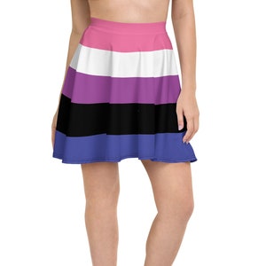 Pode incluir: Uma saia skater com um padrão de listras multicoloridas. A saia tem listras rosa, brancas, roxas, pretas e azuis.