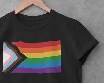 May include: Black t-shirt with a rainbow pride flag with a brown, light blue, pink, and white triangle in the corner.