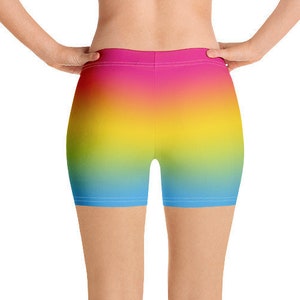 May include: A pair of athletic shorts with a gradient design featuring shades of blue, yellow and pink.