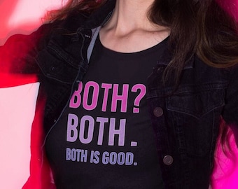 Pode incluir: Uma mulher vestindo uma jaqueta de jeans preta sobre uma camiseta preta com o texto "BOTH? BOTH - BOTH IS GOOD." em letras rosa. Ela está em pé em frente a um fundo rosa.