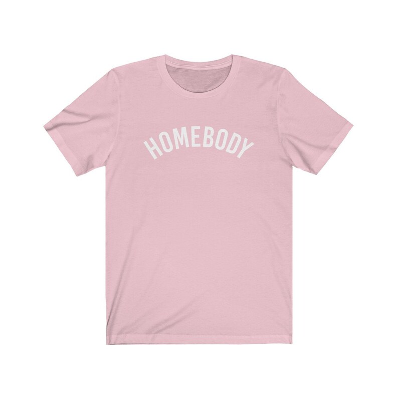May include: A pink short-sleeved t-shirt with the text "HOMEBODY" printed in white on the front.
