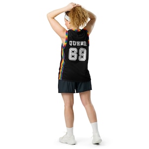 May include: A black basketball jersey with rainbow trim and the text "QUEER 69" on the back.