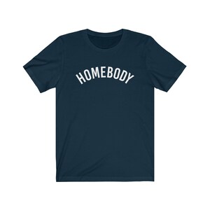 May include: A navy blue t-shirt with the word "HOMEBODY" printed in white on the front.