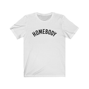 May include: White t-shirt with black text that reads "HOMEBODY" in an arc.
