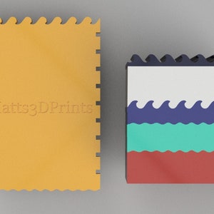 May include: Two foam puzzle mats with a wavy edge. The mat on the left is orange and has the text "Matts3DPrints" embossed on it. The mat on the right has a white top layer, a blue layer with white waves, a turquoise layer, and a red bottom layer.