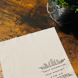 May include: White microfiber cleaning cloth with black floral border and the text "FULLY ACCOMPLISH YOUR MINISTRY" 2 TIM. 4:5