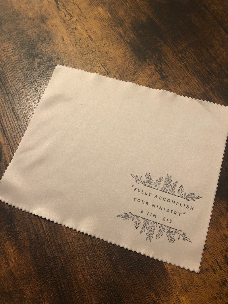 May include: A beige microfiber cleaning cloth with a black floral design and the text "FULLY ACCOMPLISH YOUR MINISTRY" 2 TIM. 4:5