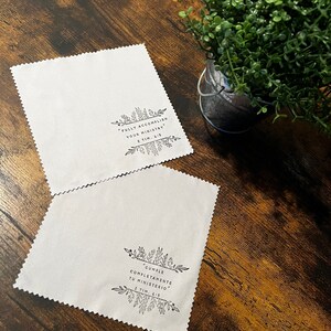 May include: Two white microfiber cloths with black floral designs and inspirational quotes. The top cloth reads "FULLY ACCOMPLISH YOUR MINISTRY 2 TIM. 4:15". The bottom cloth reads "CUMPLE COMPLETAMENTE TU MINISTERIO 2 TIM. 4:15".