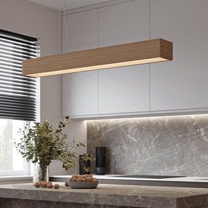 Könnte beinhalten: Eine moderne Kücheninsel mit einer braunen Marmorarbeitsplatte und zwei schwarzen Barhockern. Die Insel hat eine weiße Rückwand und einen schwarzen Wasserhahn. Eine Holzleuchte hängt über der Insel.