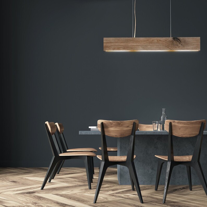 May include: A dining room table with a dark gray concrete top and black metal legs. Four black chairs with wooden seats surround the table. A wooden rectangular light fixture hangs above the table.