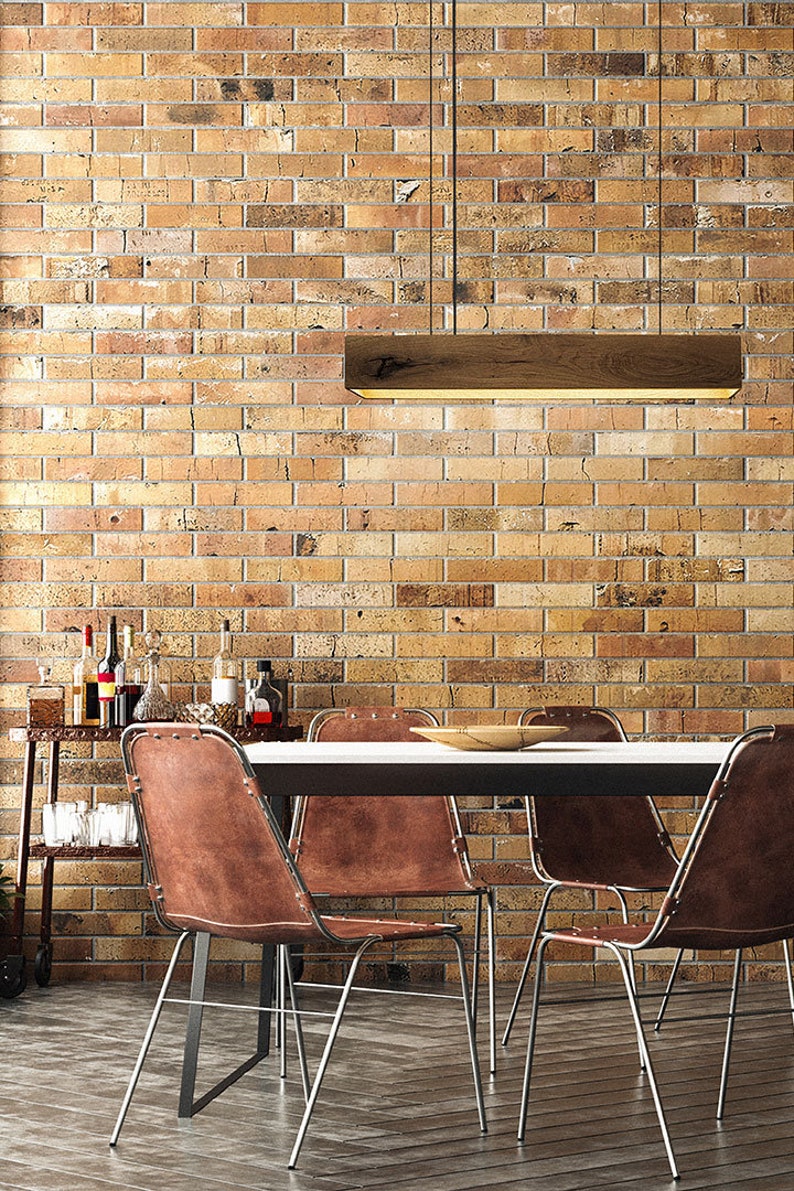 May include: A dining room table with four brown leather chairs with metal frames. The table has a white top and a black base. A wooden light fixture hangs above the table.