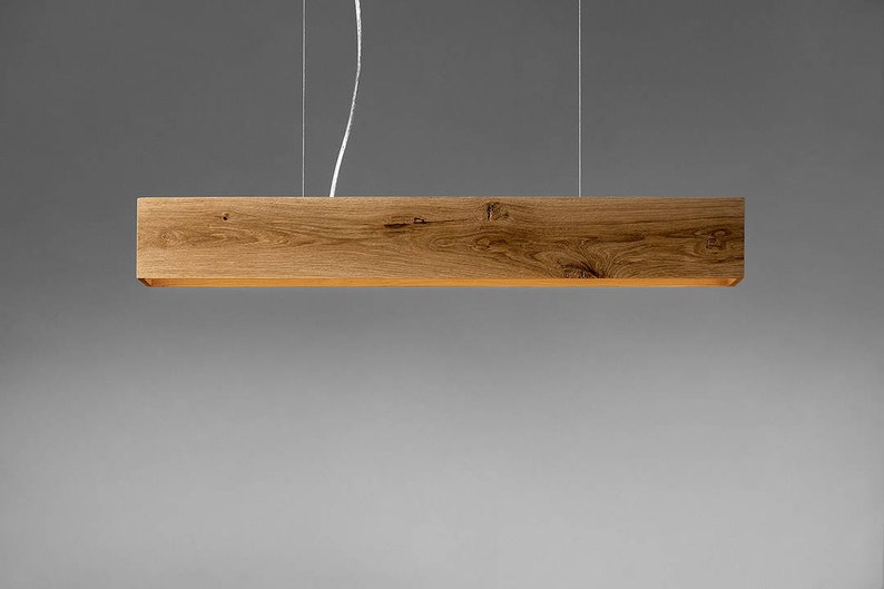 May include: A wooden pendant light fixture with a rectangular shape and a natural wood finish.