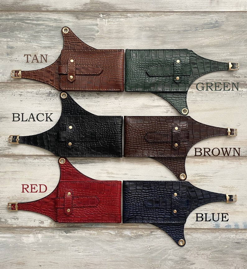 May include: Five leather belts with different colored crocodile embossed patterns. The belts are labeled "TAN", "GREEN", "BLACK", "BROWN", and "BLUE".