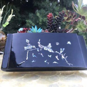 May include: A black rectangular decorative box with a glossy finish. The box is decorated with mother-of-pearl inlay showing birds on a branch. The box is filled with succulents and other plants.